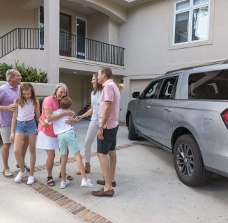 a multigenerational family standing outside of a vacation home