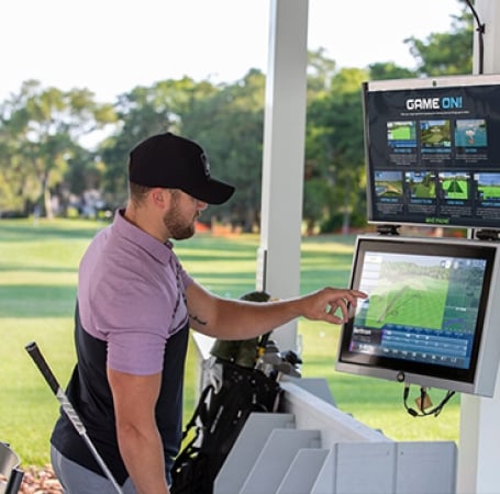 man setting up a golf simulator