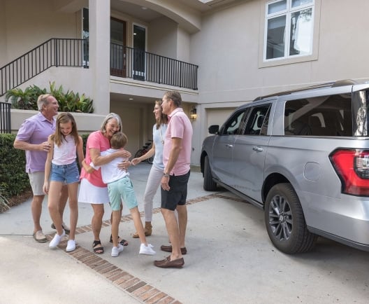 a multigenerational family standing outside of a vacation home