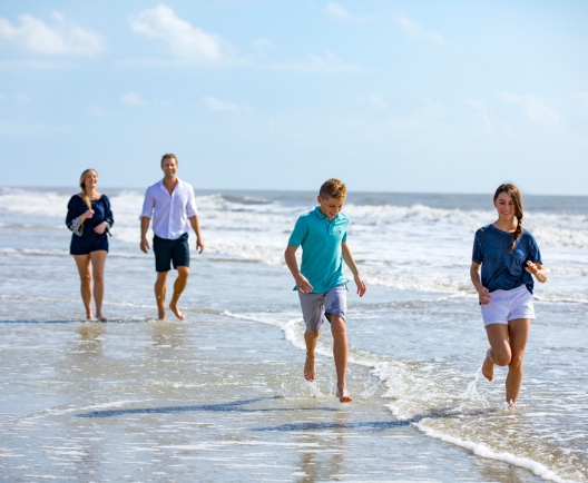 family splashing in the water on the beach 