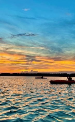 boats in front of a colourful sunset