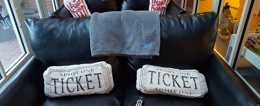 A couch with two pillows made to look like theater tickets. 